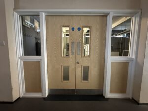 Double wooden doors with glass panels.