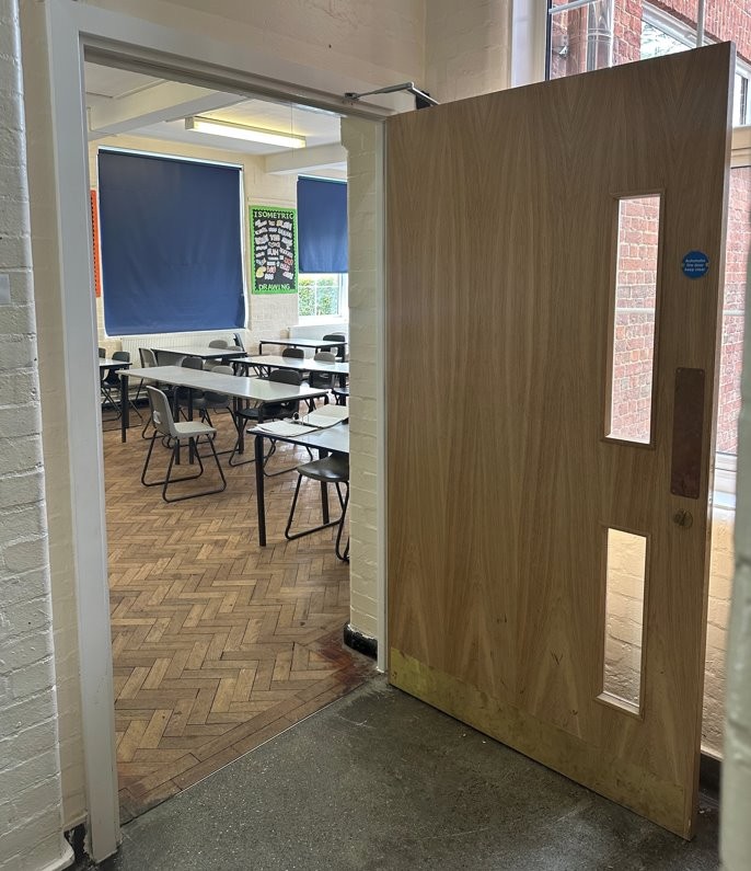 CIF-funded school refurbishment showing newly installed classroom fire door and upgraded learning environment.