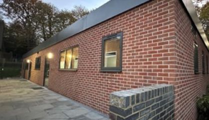 Modern brick building with windows and outdoor lighting.