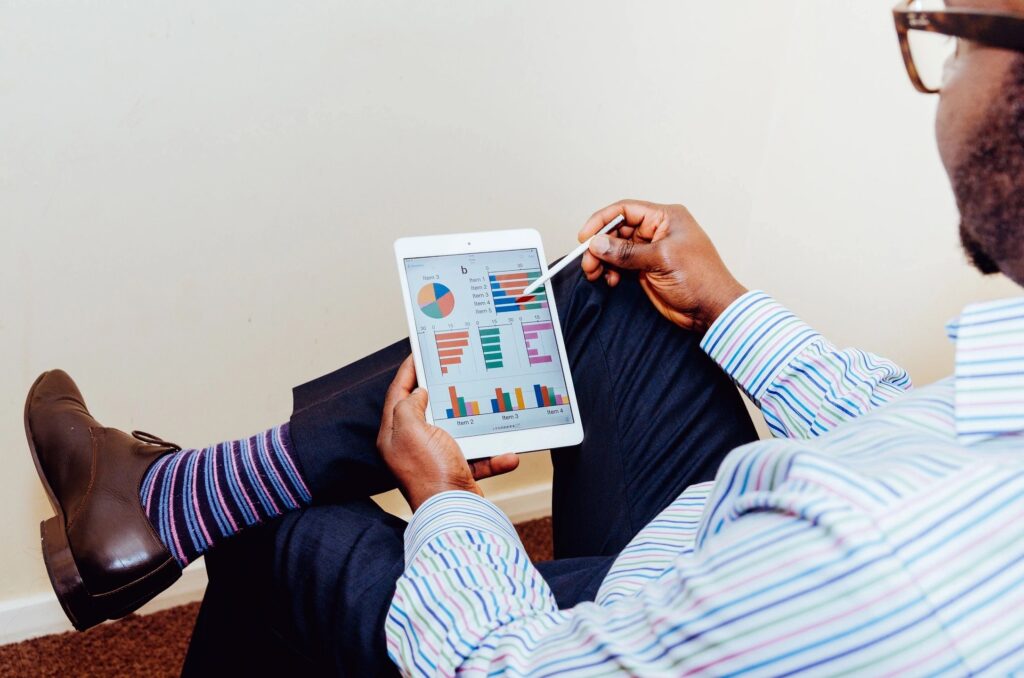 Business professional reviewing financial data and performance charts on a digital tablet for strategic planning.
