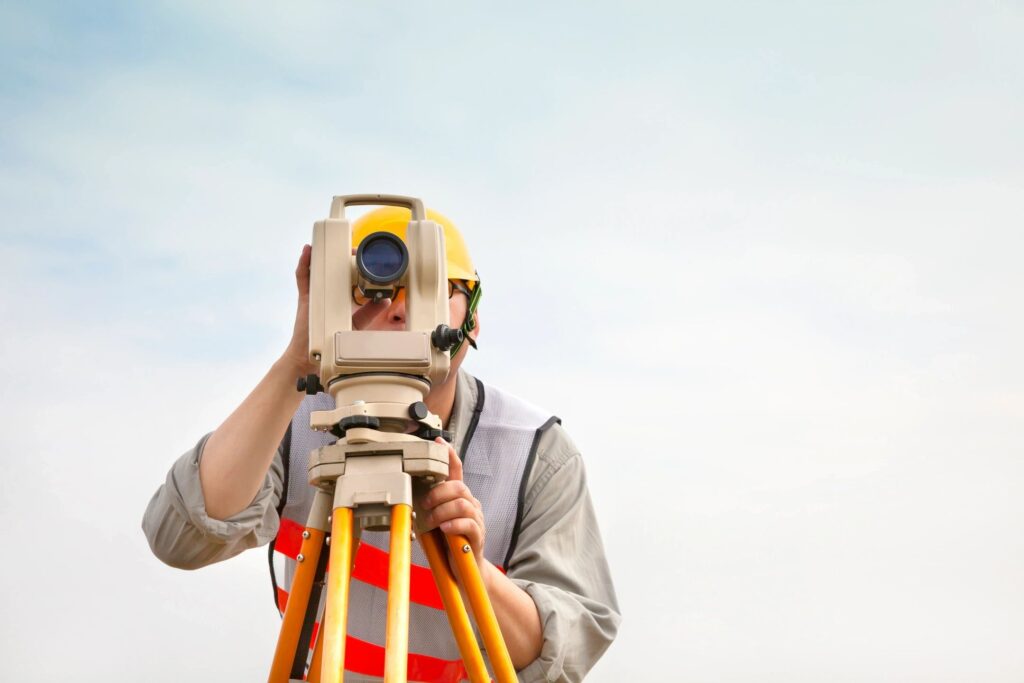 Construction surveyor using a theodolite for land measurement and contract administration purposes.