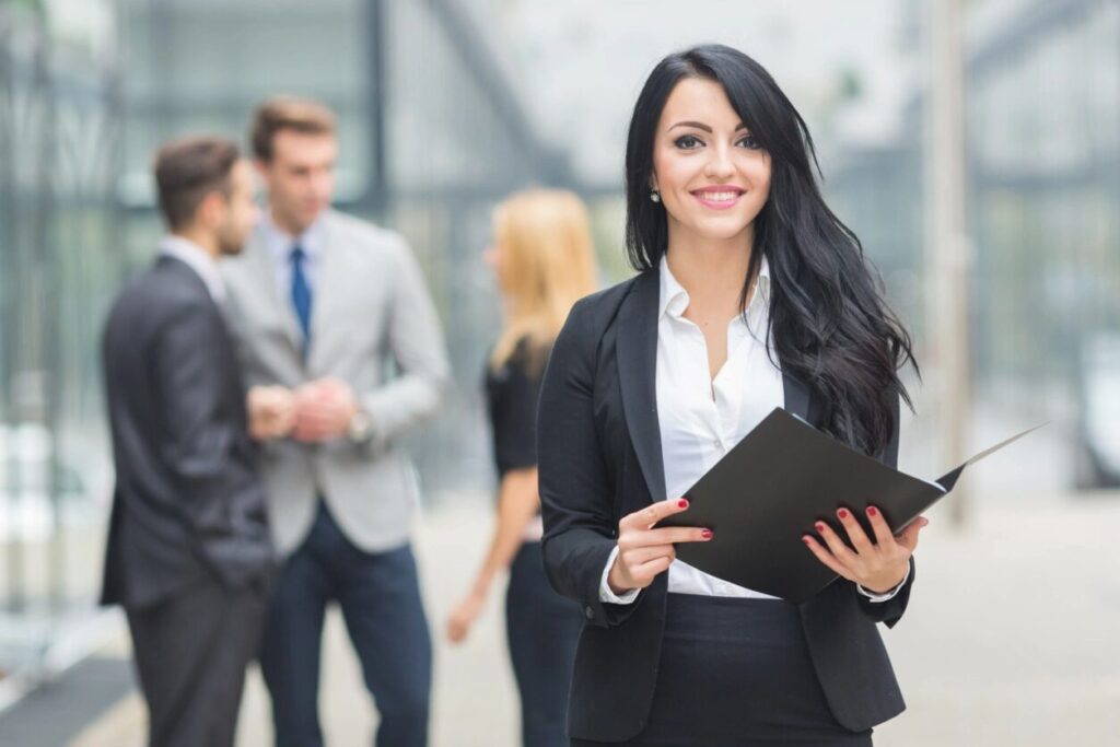 Business professional holding a folder and smiling, representing confidence in tender and contract administration.