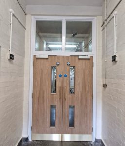 Wallington County Grammar School - Double fire doors with glass panels in school corridor.