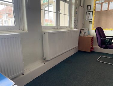 School heating upgrade funded by CIF, showing new radiator installation for improved energy efficiency and classroom comfort.