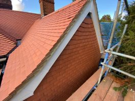 Newly tiled pitched school roof completed under CIF-funded refurbishment project with scaffolding on site.