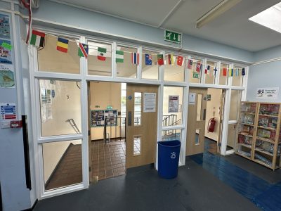 School entrance area with upgraded fire doors and emergency exit signage, ensuring safety and compliance.