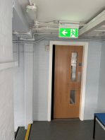 CIF-funded school fire safety upgrade with new fire door installation and emergency exit signage.
