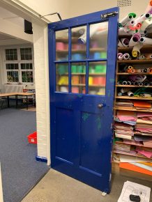 Worn blue classroom door in need of CIF refurbishment funding.