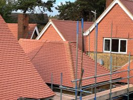 CIF-funded school roof replacement with new tiled roofing and scaffolding during refurbishment project.
