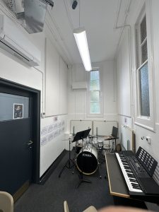 Small music practice room with drum kit and keyboard