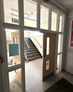 School stairwell with newly fitted fire safety doors and glazed partitions, improving security and compliance with building regulations.