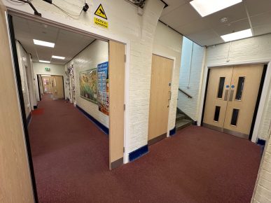 Refurbished school corridor with new CIF-funded fire doors and modern finishes.
