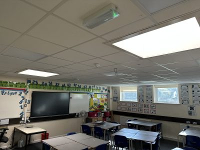 Refurbished classroom with new suspended ceiling, modern LED lighting, and interactive smartboard to enhance the learning environment.