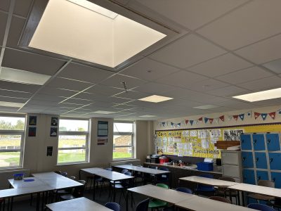 Modernised classroom with suspended ceiling, new LED lighting, and improved natural light for a brighter learning environment.