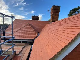 CIF-funded school roof replacement with new red tiles and chimney detailing during refurbishment project.