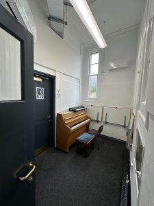 Music practice room with upright piano and acoustic treatment