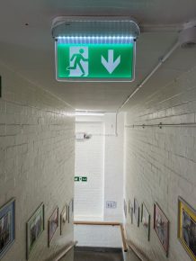 Upgraded emergency exit lighting in a school stairwell, installed through CIF funding to improve safety and compliance.