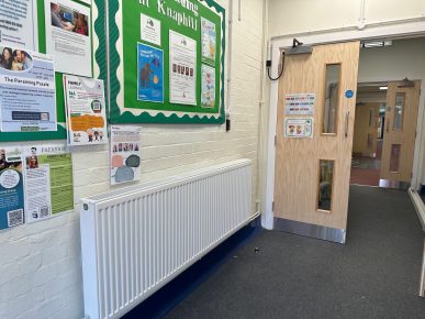 School corridor with noticeboard and fire door.