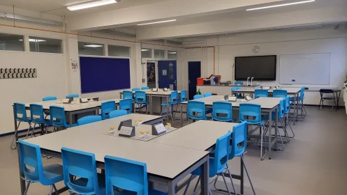 Spacious science lab with organised workstations, interactive whiteboard, and lab services neatly integrated.